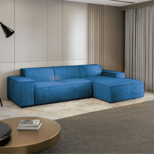 Rogówka Cancun w niebieskiej wersji kolorystycznej, ustawiona pod kątem w jasnym pokoju. Sofa tapicerowana sztruksem.