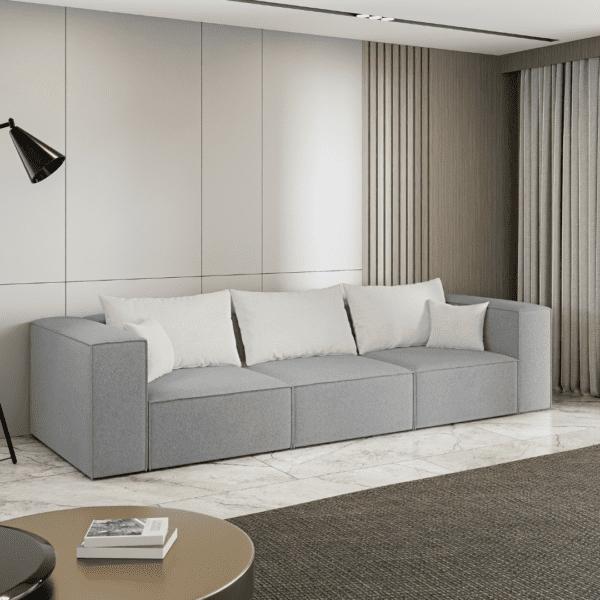 Sofa trzyosobowa w kolorze szarym, ustawiona w nowoczesnym salonie, widok boczny. Fotografia inspiracyjna.