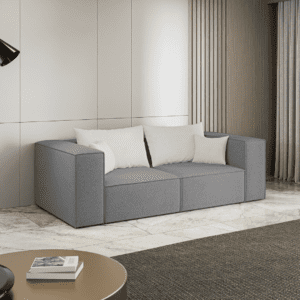 Szara sofa ustawiona w jasnym, nowoczesnym wnętrzu, widok z boku. Inspiracyjne zdjęcie pokazujące stylowe zastosowanie.
