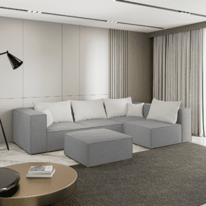 Sofa narożna z pufą w kolorze szarym, widok z boku w nowoczesnym wnętrzu. Inspiracyjne zdjęcie pokazujące zastosowanie.